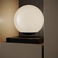 Modern Minimalist Table Lamp With White Globe Shade And Black Base On Wooden Surface