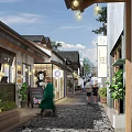 Traditional Commercial Street With Cobblestone Path Shops Pedestrians Green Plants And Hanging Lights