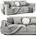 Cozy Two Seater Sofa with Plush Pillows and Checkered Blanket Accents