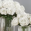 Clear Crystal Vases With White Roses And Green Leaves On Decorative Table