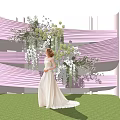 Bridal White Gown Standing By Pink White Decorative Structure With Floral Arrangement On Green Grass