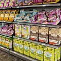 Retail Display Shelves Stocked With Various Snacks Drinks And Packaged Goods In Modern Store