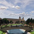 Scenic Landscape With Stone Bridge Water Pool Green Lawns And Historic Buildings Under Blue Sky