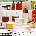 Perfume And Cosmetic Products With Golden Caps White Lids And Glass Containers On Display Shelf
