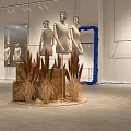 Modern Window Display With Three Mannequins Orange Circular Backdrop Dried Grass And Wooden Stumps