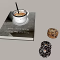 White Coffee Cup with Stirrer on a Thick Book and Donuts with Sprinkles and Ribbon