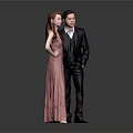 Couple In Pink Gown And Black Suit Against Gray Background