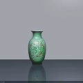 Green Ceramic Vase with Intricate Floral Patterns on Gray Table and Light Gray Wall