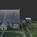 Urban Building Complex Showcasing Traditional Stone Church Small Houses And Green Lawns