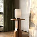 Wooden Side Table With Round Top And White Pleated Lampshade Near Green Curtains Window