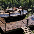 Scenic Park Landscape With Wooden Deck Stairs Railings And Lush Green Trees