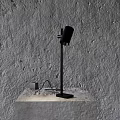 Black Modern Desk Lamp on Concrete Pedestal Against Textured Gray Wall