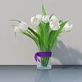 White Tulips in Transparent Glass Vase With Purple Ribbon on Gray Tabletop
