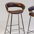 Two Brown Leather Bar Stools With Curved Backrest And Modern Metal Legs Design