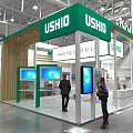 USHIO Exhibition Booth With Green Canopy Wooden Structure And Display Screens