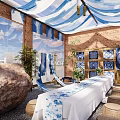 Maybach Display Area Featuring Blue White Striped Canopies Brick Walls Long Table And Stone Stools