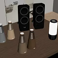 Various Stylish Speaker Devices With Gold Silver And Black Designs On Wooden Table