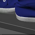 Three Pairs of Blue Canvas Shoes Displayed on a Black Shelf