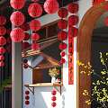 Traditional Chinese Courtyard With Red Lanterns Wooden Archway Calligraphy Scroll And Yellow Flowers
