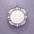 Round Mirror with Pink and Gold Decorations Reflecting Bedroom with Bed and Nightstand