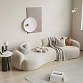 Beige Curved Multi Person Sofa With Decorative Pillows Throw Blanket And Wall Art