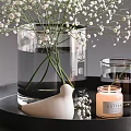 Transparent Vase With White Baby's Breath Flowers On Black Tray With Candles And Bird Ornament
