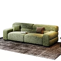 Green Upholstered Sectional Sofa with Two Colored Pillows on Brown Rug and Books on Seat