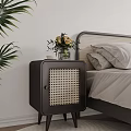 Dark Rattan Panel Bedside Table With Vase Flowers And Cup In Bedroom