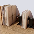 Stacked Books And Magazines Bound With String And Black Bookends On Wooden Floor