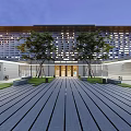 Modern Museum Building Exterior With Illuminated Windows Courtyard Trees And Wooden Walkway