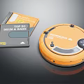 Orange Robot Vacuum Cleaner With Music CDs On Black Surface