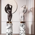 Black And White Nude Female Sculptures With Marble Pedestals And Circular Decorative Wall Background