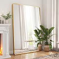 Large Gold Framed Mirror In Living Room With White Fireplace And Green Plant