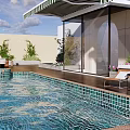 Modern Swimming Pool With Lounge Chairs Umbrella Plants And Wooden Deck