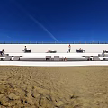 Outdoor Chairs On Beach With People Sitting Under Blue Sky And Railing Wall
