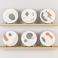 Decorative Plates With Abstract Geometric Patterns On Wooden Shelves In Neutral Tones