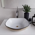 White Square Wash Basin With Black Rim Modern Faucet And Green Plant On White Countertop