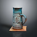 Handcrafted Carved Ceramic Mug With Blue Brown Glaze And Sculpted Patterns On Wooden Base