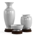 White Ceramic Vessels with Crackle Texture in Different Shapes on Wooden Bases