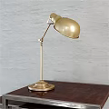 Brass Table Lamp With Adjustable Arm And Round Base On Dark Wooden Table Textured Wall