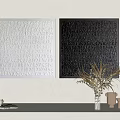 White And Black Square Textured Artworks With Raised Letter Patterns And Potted Plant