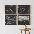 Four Framed Artworks Featuring Animal Figures Abstract Designs And Vase On Wooden Table