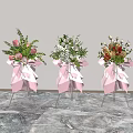 Three Floral Vases with Pink Decorative Bows and Various Flowers on Metal Stands