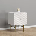 White Nightstand with Two Textured Drawers and Gold Legs Against Gray Wall on Wooden Floor