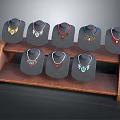Jewelry Necklaces On Two Tiered Wooden Display Stand With Black Mannequins And Colorful Designs