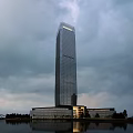 Modern High Rise Office Building with Glass Curtain Wall Waterfront Reflection and Surrounding Trees