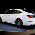 Modern White Sedan Car Featuring Sleek Exterior And Alloy Wheels On Display Stand