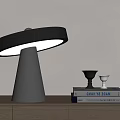Modern Table Lamp with Conical Base Round Shade on Wooden Cabinet with Books and Decor