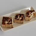Three Classic Tiramisu Cakes On White Rectangular Tray With Cream Balls And Cocoa Powder