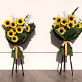 Floral Display With Sunflowers Green Wrapping And Orange White Ribbons On Black Tripods
